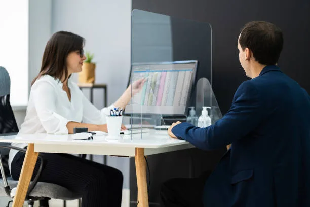Consultora e cliente em reunião na mesa de trabalho